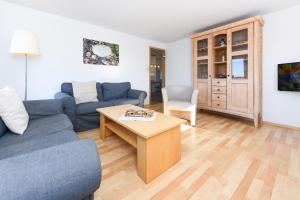 sala de estar con sofá y mesa en Haus Hafenblick, en Bensersiel