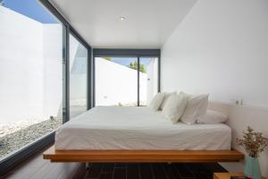 Schlafzimmer mit einem Bett mit weißer Bettwäsche und Fenstern in der Unterkunft ELEGANTE Y SOFISTICADA VILLA DE 5 HABITACIONES in Los Caños de Meca