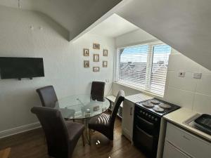 a kitchen with a glass table and chairs in a room at Luxury Loft suite ideal theatre digs in Blackpool