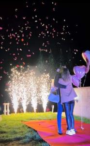 two people standing in front of a fountain with balloons at Vila Gavrić in Zvornik
