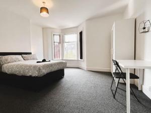 a white bedroom with a bed and a desk at Salisbury Place by SG Property Group in Crewe