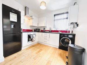uma cozinha com um frigorífico preto e uma máquina de lavar louça em Salisbury Place by SG Property Group em Crewe