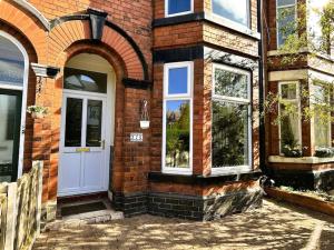 uma casa de tijolos com uma porta branca e janelas em Salisbury Place by SG Property Group em Crewe