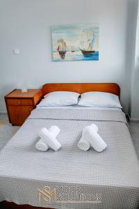 a bed with two towels on top of it at Dryades Pefkochori MoodSolutions Living in Pefkohori