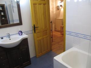 un bagno con lavandino, specchio e porta di La Plazuela a Morcuera Altre 19 foto