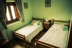 due letti in una stanza con pareti verdi di La Plazuela a Morcuera