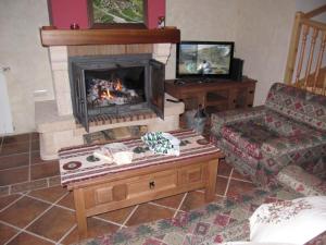 un soggiorno con camino e divano di La Plazuela a Morcuera