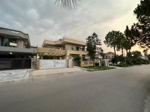 una grande casa con un cancello bianco su una strada di Decent Lodge Guest House F-11 a Islamabad