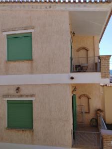 a building with green doors and a balcony at Didima in Didyma