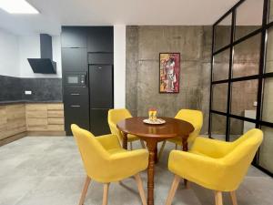 a dining room with a table and yellow chairs at Apartamento Naranja in Bolnuevo