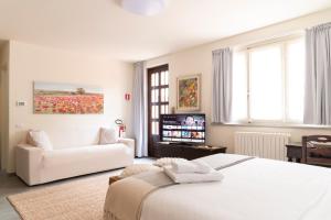 Dormitorio blanco con cama blanca y sofá en FLOWERS ROOM stanza privata tra Como e Milano, en Vertemate
