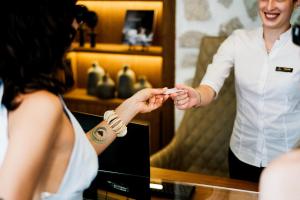 Um noivo a pôr a aliança na mão de uma mulher. em Casa Manor Boutique Hotel em Tivat