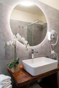 y baño con lavabo blanco y espejo. en FLOWERS ROOM stanza privata tra Como e Milano, en Vertemate