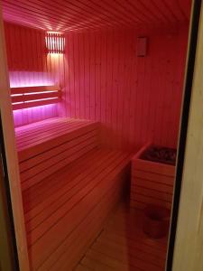 una pequeña sauna con luces rosas en una habitación en Waterhill's Bed & Wellness en Dinteloord