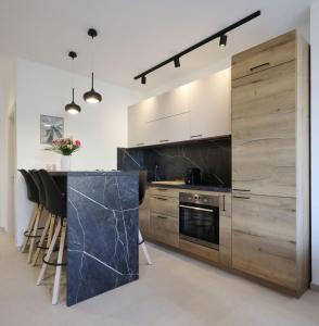 a kitchen with wooden cabinets and a counter with stools at Apartments Maestral in Medulin