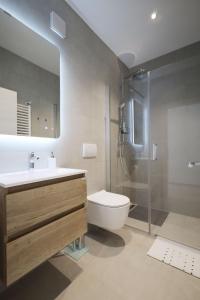 a bathroom with a sink and a toilet and a shower at Apartments Maestral in Medulin