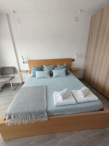 ein Schlafzimmer mit einem großen Bett mit blauer Bettwäsche und Kissen in der Unterkunft Apartamento con vistas in Arenys de Munt