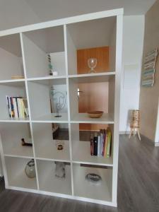une étagère blanche avec des livres sur elle dans l'établissement Apartamento con vistas, à Arenys de Munt
