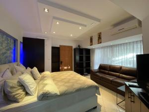 a bedroom with a bed and a couch at Eilat Beach House in Eilat