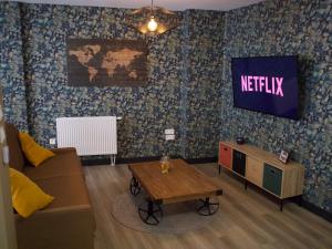 聖奧梅爾的住宿－Le Moment Détente - Appartement avec balnéothérapie，带沙发和电视的客厅