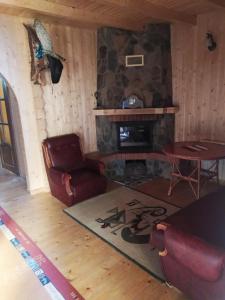 ein Wohnzimmer mit einem Kamin und einem Tisch in der Unterkunft Котедж,,Гуцульське Рандеву'' in Iltsi