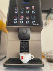 a coffee machine with a cup on a keyboard at Hotel Diamond in Limenaria