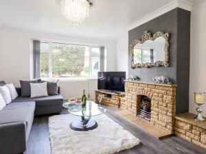 a living room with a couch and a fireplace at The Blossom Woods in High Wycombe