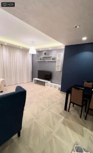 a living room with a table and a blue wall at شاليه فندقي بحمام سباحه خاص داخل فندق ايليت ريزيدنس اند اكوا بارك in Ain Sokhna