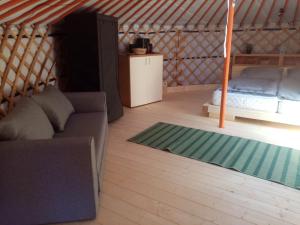 a room with a couch and a bed in a yurt at Foxódi Lombjurta in Taliándörögd