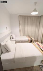 a bedroom with two beds and a couch at شاليه فندقي بحمام سباحه خاص داخل فندق ايليت ريزيدنس اند اكوا بارك in Ain Sokhna +7 photos