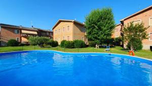 een groot blauw zwembad voor sommige gebouwen bij EDDA - Regarda Travel in Lazise