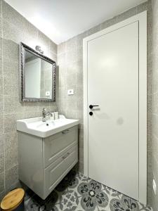 a white bathroom with a sink and a mirror at Apartments Angela in Piran +55 photos