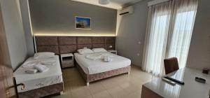 a hotel room with two beds and a window at Hotel Kolla in Derviçian
