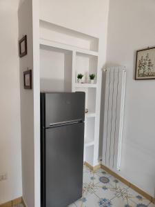 eine Küche mit einem schwarzen Kühlschrank im Zimmer in der Unterkunft The House Of The Sunbeam in Neapel