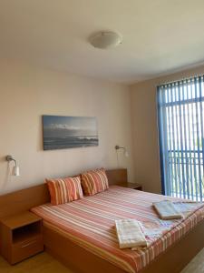 a bedroom with a bed with two pillows and a window at Prostor Apartments in Obzor +52 photos