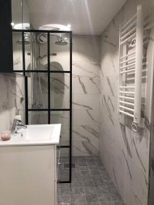 a bathroom with a sink and a glass shower at NYRENOVERAD LÄGENHET med egen ingång & nära havet in Sölvesborg