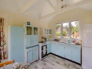 a kitchen with blue cabinets and a white refrigerator at Mahalia in Fordham