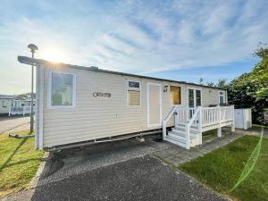 a white tiny house with a porch and stairs at 8 Berth, Dog Friendly Caravan At Haven Caister In Norfolk Ref 30031b in Great Yarmouth