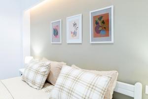 a bedroom with three pictures on the wall and a bed with pillows at Kos Olympia Apartment superior at Lambi Beach in Kos Town +13 photos