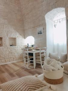 ein weißes Wohnzimmer mit einem Tisch und Stühlen in der Unterkunft Casa De Amicis in Sammichele di Bari