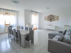 un soggiorno con tavolo, sedie e divano di Budget Beds ad Alghero