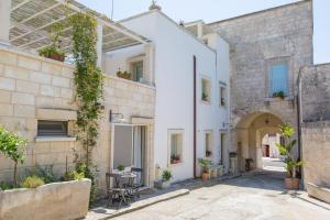 an external view of a white house with a patio at Dimora Storica La Torre Nel Borgo in Borgagne
