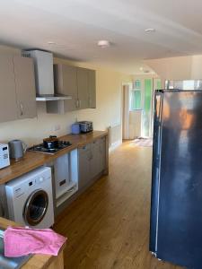a kitchen with a refrigerator and a washer at Plumpton Walk in Canterbury