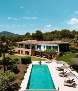 a house with a swimming pool in front of a house at Villa Golf D'or in Portocolom