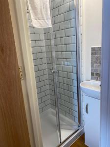 uma casa de banho com um chuveiro e um lavatório. em Plumpton Walk em Canterbury