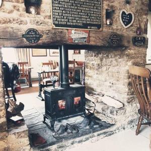 a stove in a room with a stone wall at The Great Western Arms in Clifton Hampton