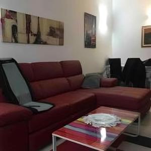 Splendido appartamento in zona fiera a bologna في بولونيا: غرفة معيشة مع أريكة حمراء وطاولة قهوة