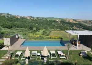 a view of a pool with umbrellas and chairs at B&B Maison Il Melograno in San Marino