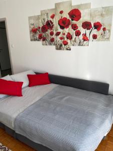 1 dormitorio con 1 cama con amapolas rojas en la pared en CASA DENDI, en Trieste