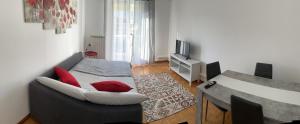 uma sala de estar com um sofá com almofadas vermelhas em CASA DENDI em Trieste